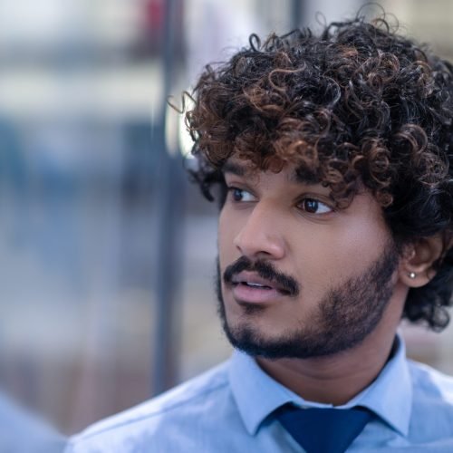 Businessman. Curly-haired young businessman in a blue shirt
